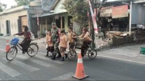 Babinsa Joyotakan Amankan Arus Lalu Lintas & Bantu Penyebrangan Siswa SDN 59 Joyotakan   